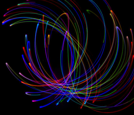 Abstract multicolored lines drawn by light on a black background. Laser lines