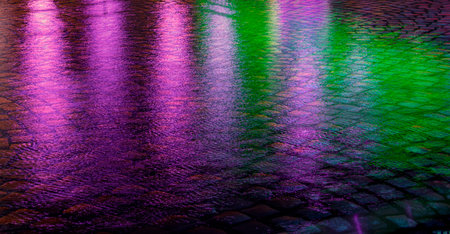 Abstract urban background. Streets after rain with reflections of light on wet roadwayの写真素材