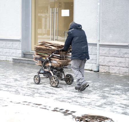 Poor man pulling a cart with cardboard in the city. Intentional motion blur. Defocused imageの写真素材