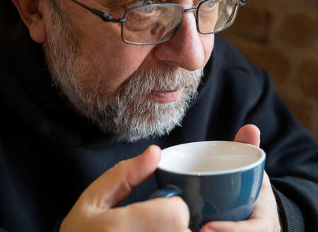 Portrait of  senior man enjoying cup of coffee in cafeの写真素材