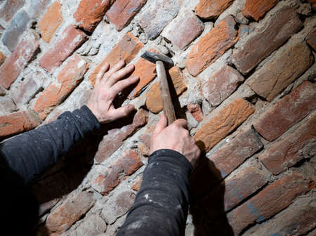 Man worker reconstructing old stone wall. Old house reconstruction, repairの写真素材