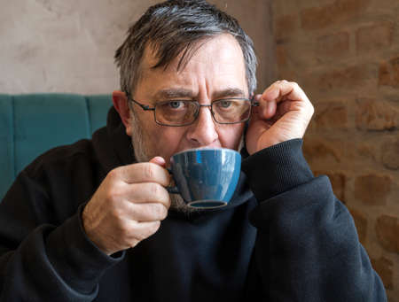 Portrait of  senior man enjoying cup of coffee in cafeの写真素材