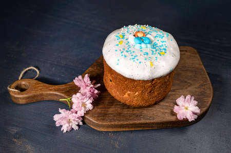 Glazed Easter cake with sprinkles on a wooden board