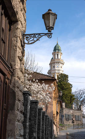 UZHHOROD, UKRAINE - APRIL 17, 2021:  Dukhnovycha street in Uzhgorod, Ukraine. Greek Catholic Cathedral on a background. Krestovozdvizhensky Cathedral is a landmark of the cityのeditorial素材