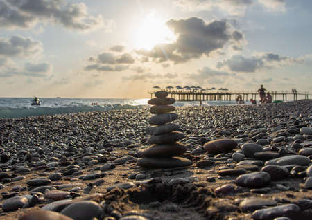 Pyramid of stones on the beach at sunset