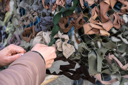 UZHHOROD, UKRAINE - MARCH 1, 2022: War of Russia against Ukraine. Volunteers making camouflage net for the armed forces of Ukraineのeditorial素材