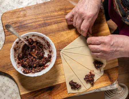 Pastry and baking concept.  Woman preparing homemade rolls with jam  at home