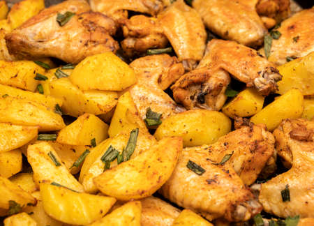 Baked chicken wings with potatoes in the ovenの写真素材