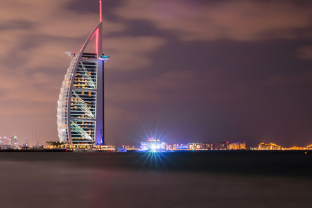 Dubai, United Arab Emirates - Dec 2, 2014 : View of the illuminated Burj Al Arab at the sunset. View from the Jumeirah beach. Burj Al Arab is a luxury 7 stars hotel built on an artificial island.のeditorial素材
