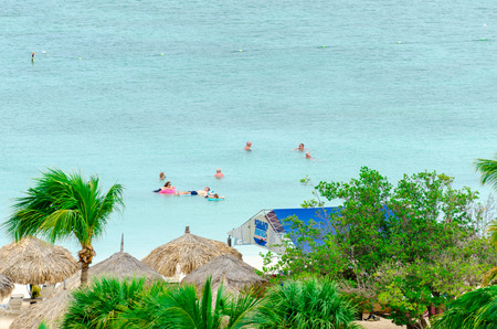 Aruba, Caribbean - September 25, 2012: Tourists enjoying the blue caribbean sea in Aruba Islandのeditorial素材