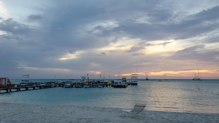 Aruba, Caribbean - September 25, 2012: Sunset with anchored sail boats on sea by the bay. The image was taken in Aruba, in the Caribbean Sea.のeditorial素材