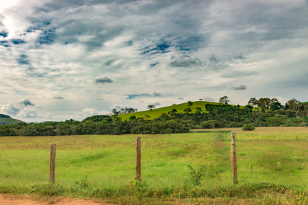 Dirt Road and barbed wire fence on summer afternoon in Minas Gerais Mountains, Brazilの写真素材
