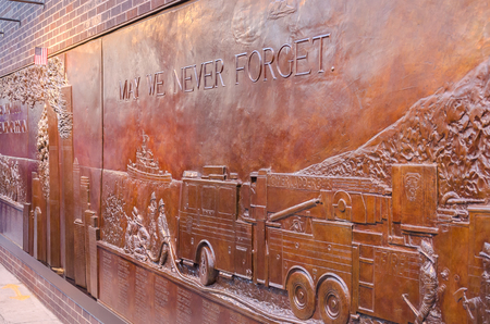 New York, USA - December 3, 2011: May We Never Forget written on the bronze bas-relief Memorial Wall at FDNY Ten House fire stationのeditorial素材