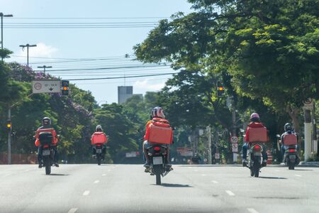 An outbreak of a pandemic disease. No cars at street at all, only bikers delivering food and packages across the city.の写真素材