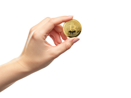 Female hand holding shiny golden bitcoin coin against white background symbolizing digital money finance technology conceptの素材