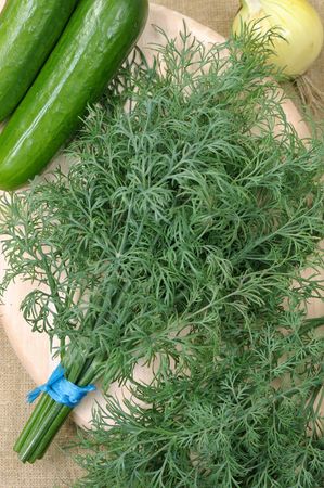 The bunch of dill lying in a basket on a mat