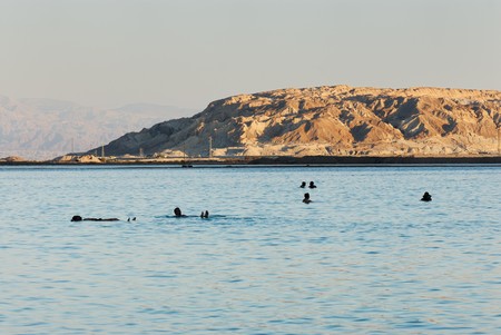 People lie on the water from the Dead Sea