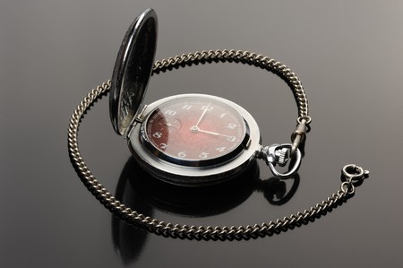 pocket watch with open cover and their reflection on a black backgroundの写真素材