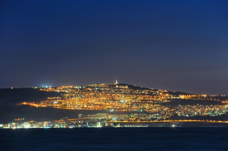 The shore of Lake Kinneret and the city of Tiberias at nightの写真素材