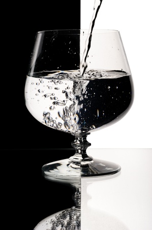 Glass with a water, on a black and white background.の写真素材