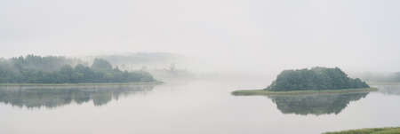Serene landscape in the fog - the shores of Lake Otolovo in Belarusの写真素材