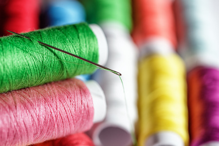Spool with thread and needle on blur backgroundの写真素材