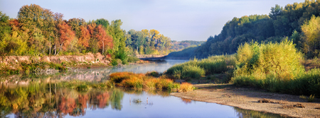 Autumn landscape with river and blue skyの写真素材