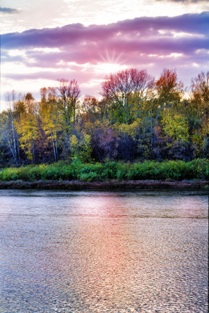 Autumn landscape with river, forest and cloudy sky.の写真素材