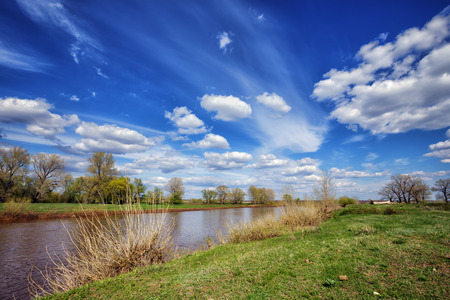 Spring landscape with river and blue skyの写真素材