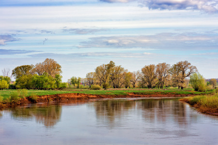 Spring landscape with river and blue skyの写真素材