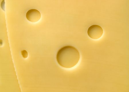 Sliced cheese with round holesの写真素材