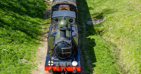 Aerial view of a vintage stream train crossing the English countryside