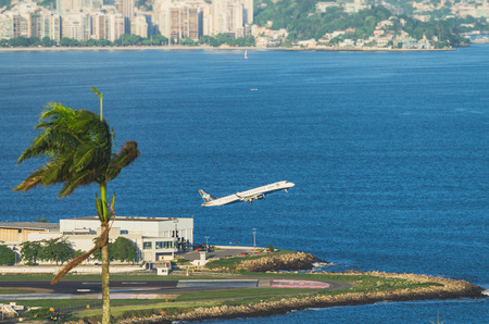 Airplane taking off from airport next to sea in Rio de Janeiro