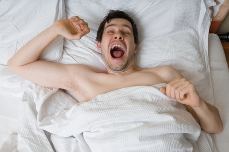 Young man is waking up in morning.