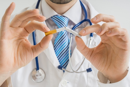 Doctor is breaking cigarette and giving advice to stop smoking.の写真素材