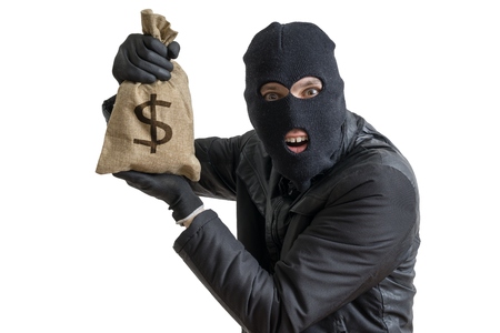 Happy robber is showing stolen bag full of money. Isolated on white background.