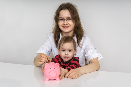 Mother with her child is holding piggy with savings.の写真素材