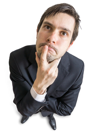 Young man is thinking and looking at you. View from above. Isolated on white background.の写真素材