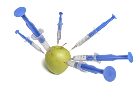 Chemicals in food concept. Syringes and apple. Isolated on white background.の写真素材