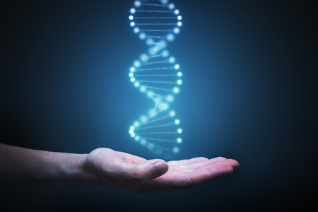 DNA and genetics research concept. Hand is holding glowing DNA molecule in hand.の写真素材