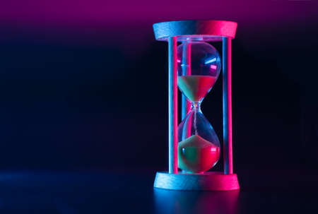 Passage of time. Hourglass on a dark background.
