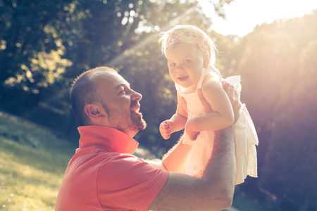 Daddy and daughter playing in the sunny dayの写真素材