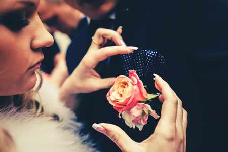 pinning flowers bouquet on the husband jacketの写真素材