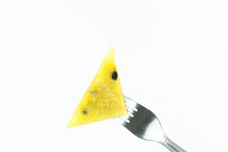 Fork stab on yellow watermelon isolate on white backgroundの写真素材