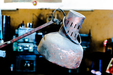 Red old metal lamp with rusty and dusty in factoryの写真素材