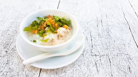 Boiled rice pork with garlic in white bowl on the wooden tableの写真素材