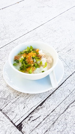 Boiled rice pork with garlic in white bowl on the wooden tableの写真素材