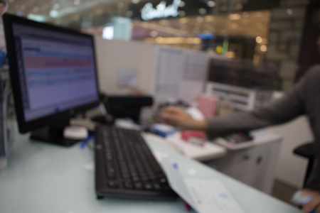 Blurry of desk with staff working on computer and keyboard, Staff is working on financial job.の写真素材