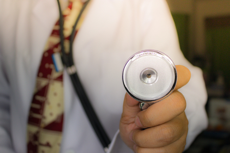 Hand of doctor who is holding a stethoscope isolated on white background, Metal silver setthoscope in man hand,の写真素材