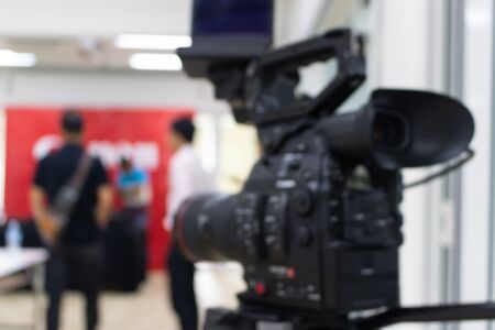 Blurry of video camera that is recording a group of people who are talking about somethingの写真素材